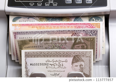 Old Pakistani rupee in a counting machine Old Pakistani rupee in a counting machine 113777857