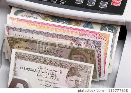Old Pakistani rupee in a counting machine Old Pakistani rupee in a counting machine 113777858