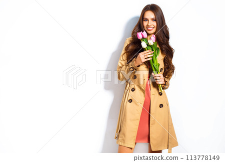 Fashion photo of beautiful woman with tulips in her hand. March 8. beautiful girl in stylish clothes Fashion photo of beautiful woman with tulips in her hand. March 8. beautiful girl in stylish clothes 113778149