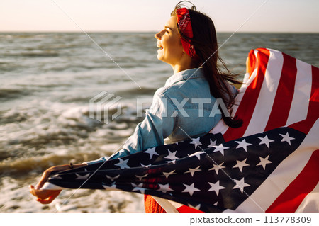 View from the back young brunette female person holding national American flag. 113778309