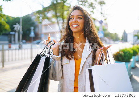 Fashion woman with shopping bags walking on street. Spring Style. Consumerism, shopping, lifestyle. Fashion woman with shopping bags walking on street. Spring Style. Consumerism, shopping, lifestyle. 113778805
