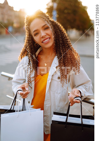 Young woman with shopping bags walking on street. , Sale concept. Young woman with shopping bags walking on street. , Sale concept. 113778869