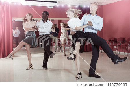 Young positive people practicing vigorous jive movements in dance class 113779065