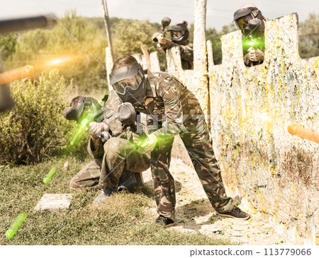 Paintball team running with marker guns 113779066