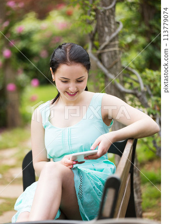 girl sitting on bench and using digital tablet 113779074