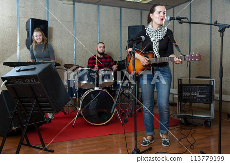 excited girl rock singer with guitar during rehearsal 113779199