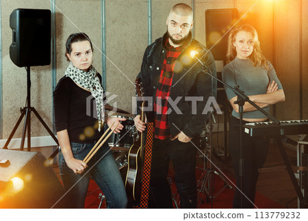 expressive group of rock musicians posing with instruments expressive group of rock musicians posing with instruments 113779232