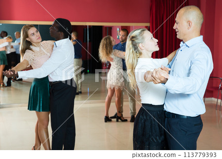 Positive people learning to dance classical dance together in dancing class 113779393