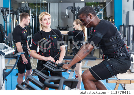 Nice female and male in EMS suit exercising Nice female and male in EMS suit exercising 113779411