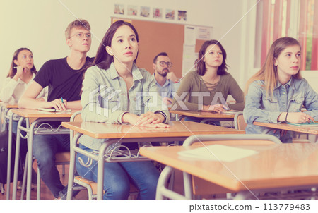 Smiling schoolgirl is learning and answering the question on paper Smiling schoolgirl is learning and answering the question on paper 113779483