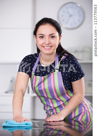 Smiling girl wiping table Smiling girl wiping table 113779563