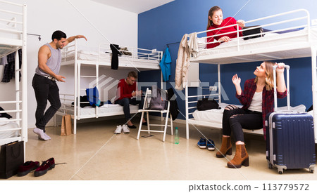 Travelers communicating in hostel bedroom Travelers communicating in hostel bedroom 113779572