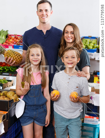 Family with children near shelves with fruits Family with children near shelves with fruits 113779598