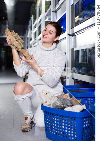 Teenager considers an unusual sandstone 113779664