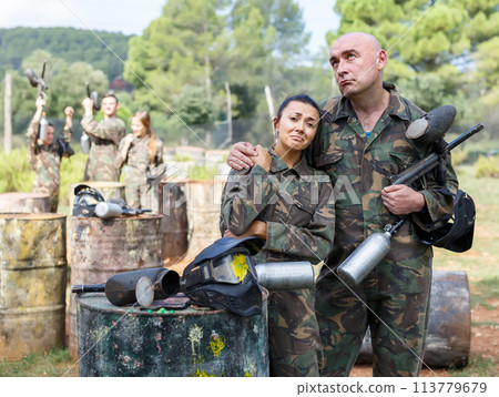 upset young people, standing outdoors with protective mask with traces of paint 113779679