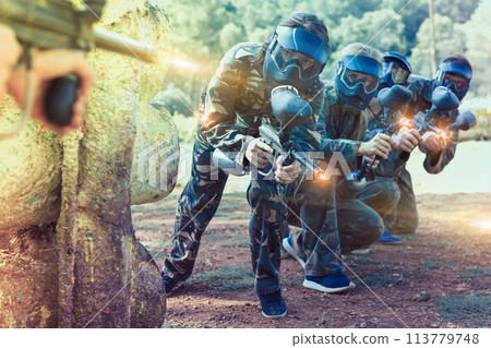 Paintball players aiming with gun Paintball players aiming with gun 113779748