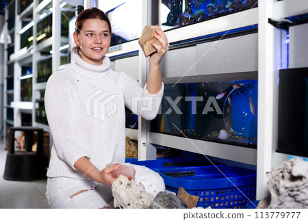 Girl choosing interesting large aquarian reefs 113779777