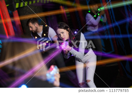 Girl playing laser tag in colorful beams 113779785