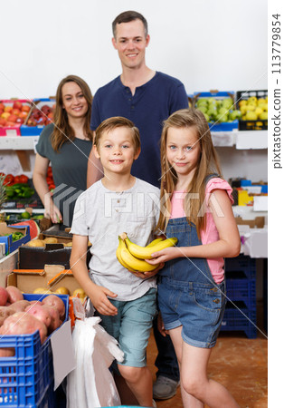 Smiling children holding delicious bananas Smiling children holding delicious bananas 113779854