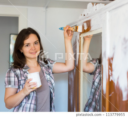 Woman makes repairs in the apartment and paints closet 113779955