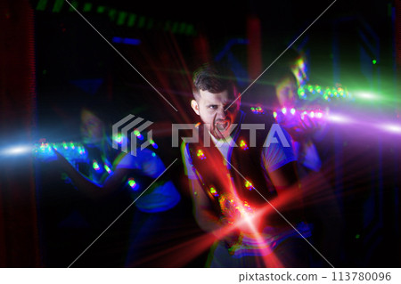 Excited guy laser tag player in bright beams 113780096
