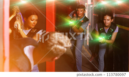 friends standing with laser guns during laser tag game 113780097