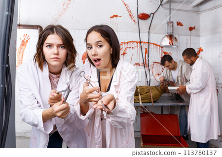 Scared girls with medical instruments in lost room Scared girls with medical instruments in lost room 113780137