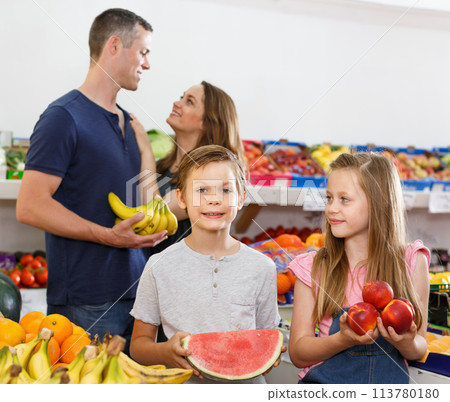 Cheery preteen kids holding fresh watermelon Cheery preteen kids holding fresh watermelon 113780180