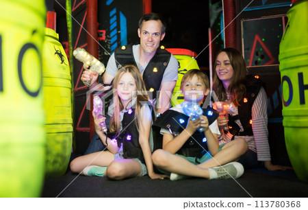 Kds and adults posing with laser guns Kds and adults posing with laser guns 113780368