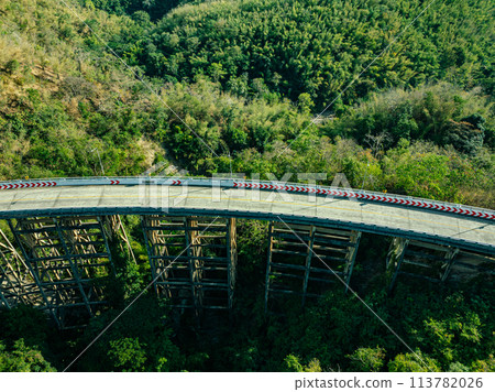 .Bridge over forest river under blue sky with green landscape and mountain view with trees.. .Bridge over forest river under blue sky with green landscape and mountain view with trees.. 113782026