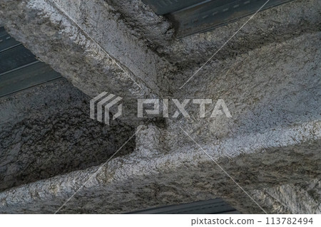 Asbestos sprayed onto the steel frame of the ceiling 113782494