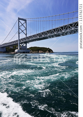 The whirlpools and large suspension bridge seen from a sightseeing boat. The whirlpools of the Naruto Strait. The whirlpools of Naruto. Popular tourist spots. 113782721