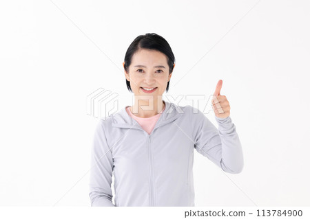 Woman in sportswear thumbs up 113784900