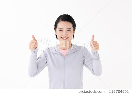Woman in sportswear thumbs up Woman in sportswear thumbs up 113784901