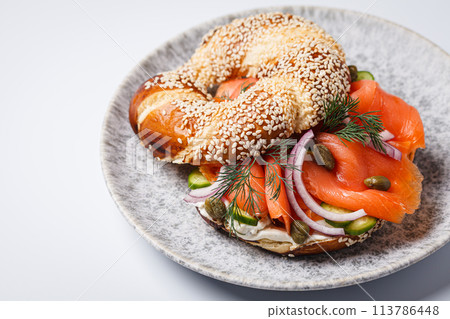 Breakfast bagel with salmon, cream cheese, capers and onions, white background. 113786448