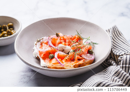 Breakfast bagel with salmon, cream cheese, capers and onions, white background. 113786449