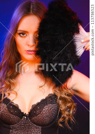 Woman holding carnival feather fan in hand. Woman holding carnival feather fan in hand. 113786523