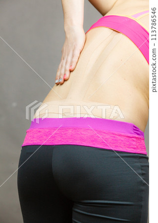 Woman with medical kinesio taping on back Woman with medical kinesio taping on back 113786546
