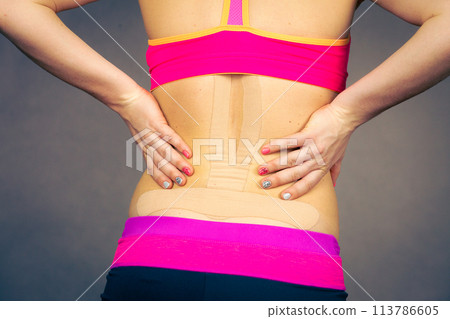 Woman with medical kinesio taping on back Woman with medical kinesio taping on back 113786605