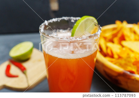 Mexican cocktail, michelada, made with beer and tomato juice. Selective focus Mexican cocktail, michelada, made with beer and tomato juice. Selective focus 113787093