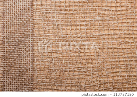 Jute ribbon on burlap cloth background Jute ribbon on burlap cloth background 113787180