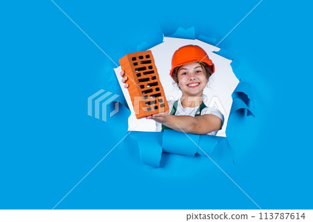 teen girl builder in protective helmet use brick, building 113787614