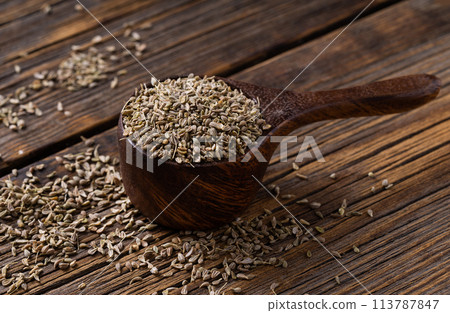 Pile of anise spice on wooden spoon. Pile of anise spice on wooden spoon. 113787847