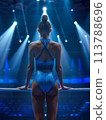 Focused on her balance beam routine, the female gymnast excels under the spotlight of the gym lights 113788696