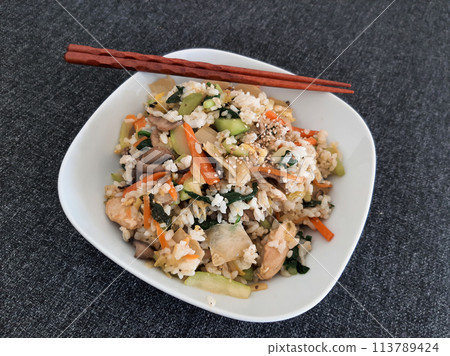 Bibimbap dish of meat, rice, vegetables and egg served on a white plate Bibimbap dish of meat, rice, vegetables and egg served on a white plate 113789424