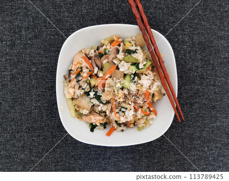 Bibimbap dish of meat, rice, vegetables and egg served on a white plate 113789425
