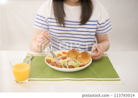 Teenage girl eating breakfast 113793014