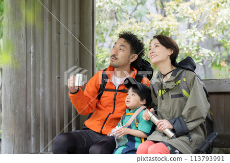 A scene of a family resting in a gazebo while enjoying mountain climbing, hiking, trekking, etc. 113793991