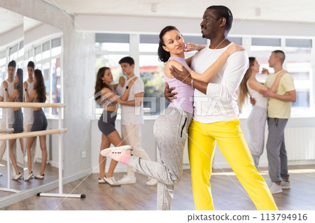 Woman dances incendiary tango with African man partner during choreography lesson 113794916
