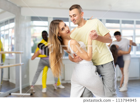 Man and young woman dancing waltz in couple during lesson at studio 113794945
